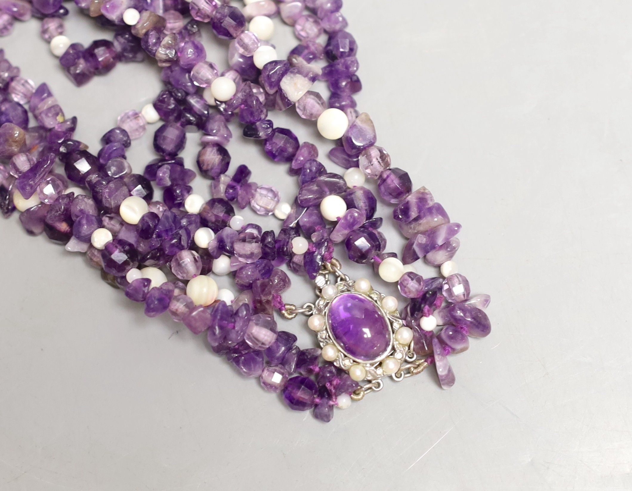 A quadruple strand amethyst pebble necklace, with white bead spacers and white metal clasp, 50cm